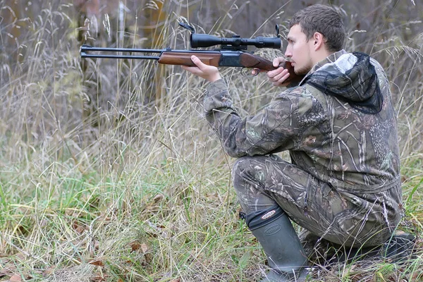 Uomo in camuffamento e con le pistole in una cintura forestale su una molla hun — Foto Stock