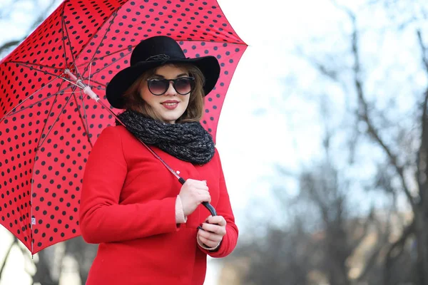 Vacker flicka på en promenad med ett paraply i staden — Stockfoto