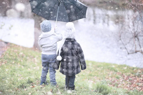 Çocuklar parkta ilk kar yürümek — Stok fotoğraf