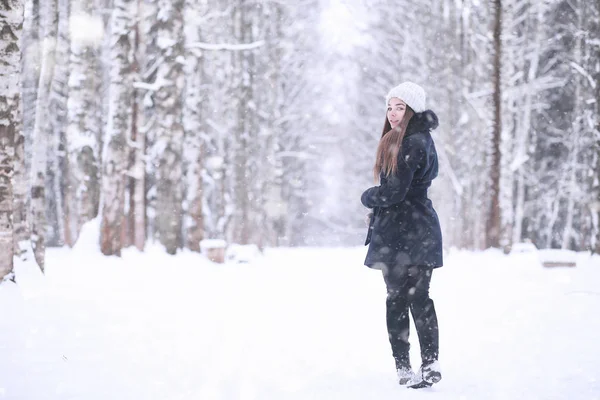 Lány a téli parkban hóesésben — Stock Fotó
