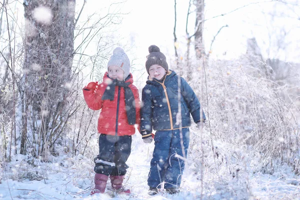 Los niños caminan en el parque primera nieve — Foto de Stock