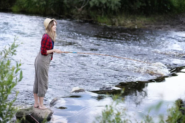 Flickan vid floden med ett fiskespö — Stockfoto