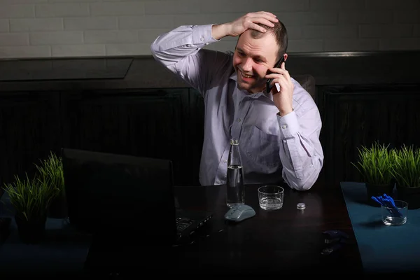 Homme assis à table et travaillant sur un ordinateur portable — Photo