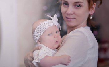 Anne kucağında yeni doğmuş bir bebekle. Kızın kucağında bir bebek var. 