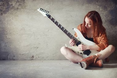 Kızıl saçlı kız bir elektro gitar ile. Rock müzisyen GIR