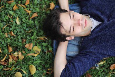 Genç bir adam öğle yemeği zamanında parkta yürür. Bir adam yürüyüşe çıktı. 