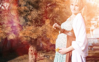 Hamile kız parkta bir yürüyüş. CI karnından kızla