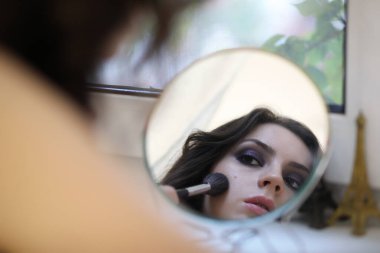 Güzel kız makyaj yapıyor.