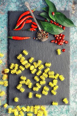 Taş zeminde pişmemiş makarna. Baharat ve baharatlarla