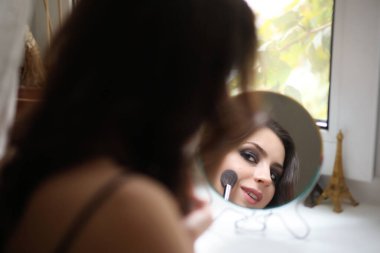 Güzel kız makyaj yapıyor.