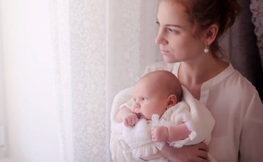 Anne kucağında yeni doğmuş bir bebekle. Kızın kucağında bir bebek var. 