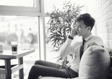 Genç Asyalı işadamı bir kafede bir ortak için bekliyor. Bu