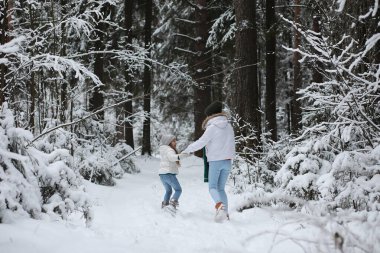 Genç bir aile yürüyüşe çıktı. Anne ve kızı şarapla yürüyorlar.