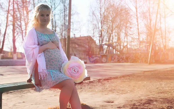 Une fille enceinte en promenade dans le parc. Fille avec un ventre dans le ci — Photo