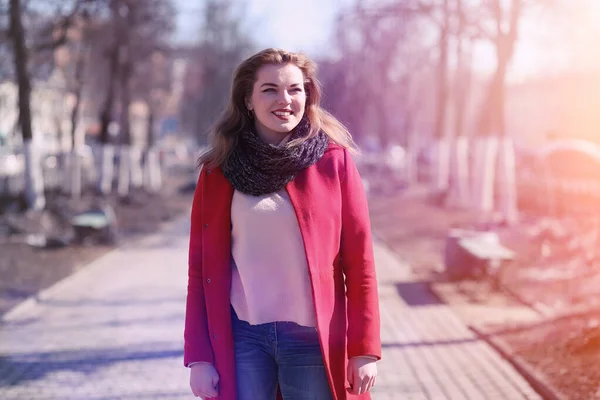 Menina bonita em um passeio em casaco vermelho na cidade — Fotografia de Stock