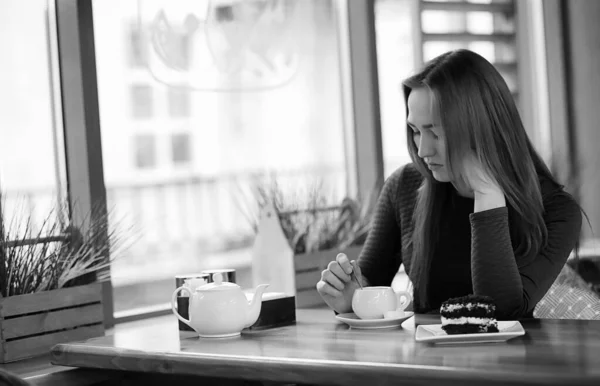 Flicka på ett café sitter och dricker te — Stockfoto