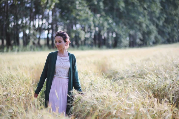 Uma jovem mãe caminha em campos de trigo — Fotografia de Stock
