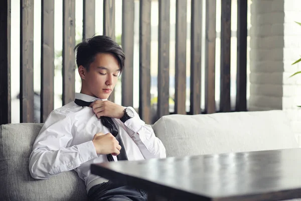 Un joven empresario asiático está esperando a un socio en un café. Bu. —  Fotos de Stock