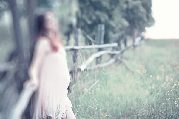 Chica embarazada en un vestido en la naturaleza — Foto de Stock