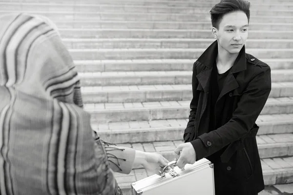 Ázsiai férfi egy fém bőröndöt a városban. Ázsiai és ezüst ca — Stock Fotó