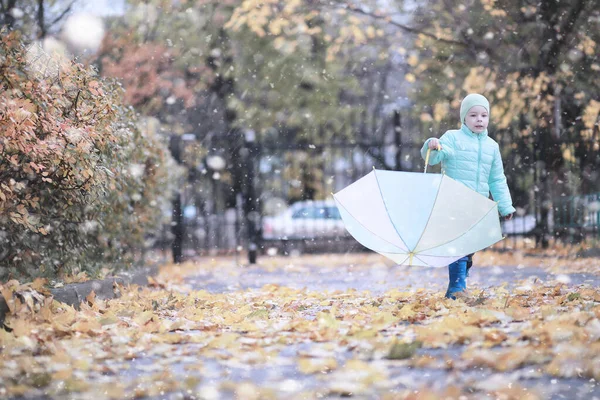 Dzieci chodzą w parku pierwszy śnieg — Zdjęcie stockowe