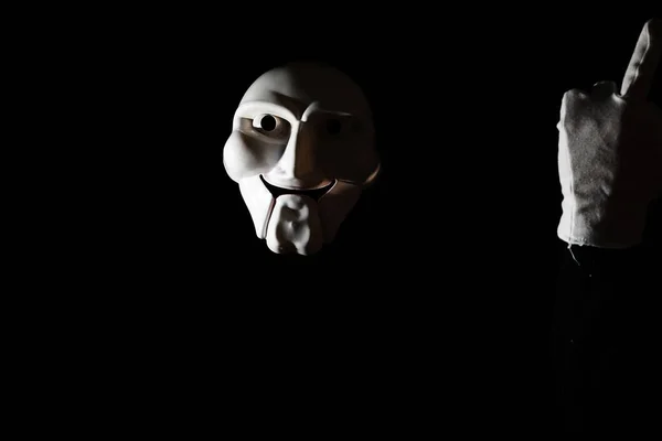 Máscara espeluznante blanca sobre fondo negro con mano blanca . — Foto de Stock