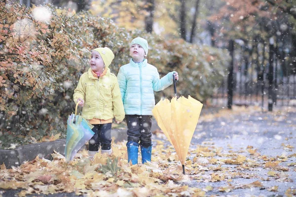 Crianças caminham no parque primeira neve — Fotografia de Stock