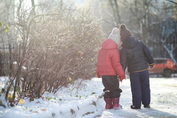 cute children in warm clothes playing in winter park