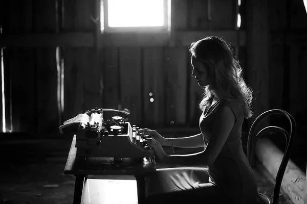 Una chica imprime en una vieja máquina de escribir — Foto de Stock
