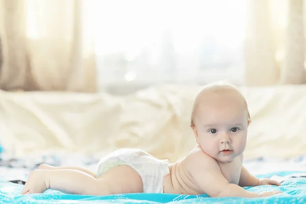 Um bebê recém-nascido está deitado em uma cama macia . — Fotografia de Stock