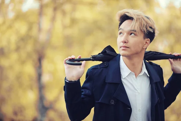 Automne temps pluvieux et un jeune homme avec un parapluie — Photo