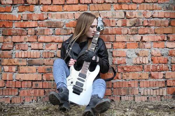 A rock musician girl in a leather jacket with a guitar — Stock Photo, Image