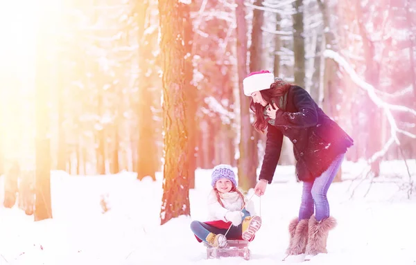 Un cuento de hadas de invierno, una joven madre y su hija montan en un trineo — Foto de Stock