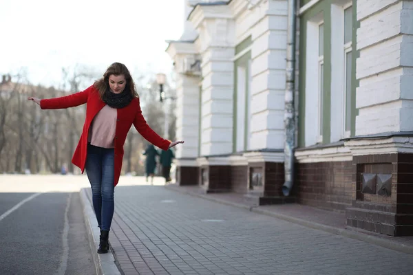 Hübsches Mädchen auf einem Spaziergang im roten Mantel in der Stadt — Stockfoto