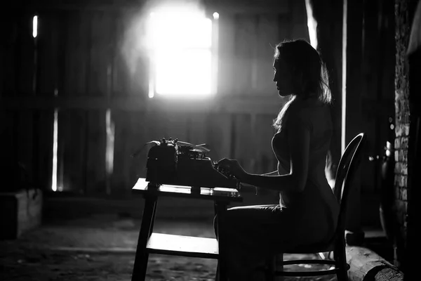 Una chica imprime en una vieja máquina de escribir — Foto de Stock