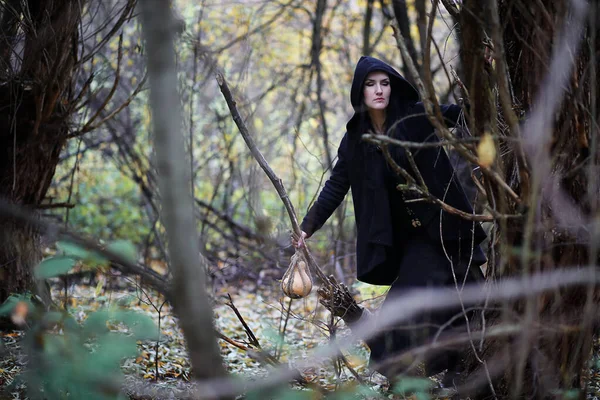 Une femme en costume de sorcière dans une forêt — Photo