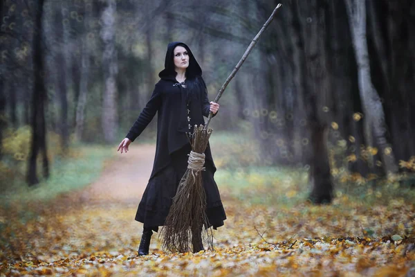 Une femme en costume de sorcière dans une forêt — Photo