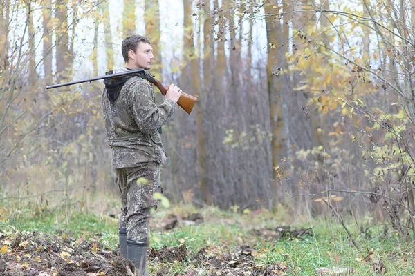 Hombre en camuflaje y con armas en un cinturón forestal en un hun de primavera — Foto de Stock