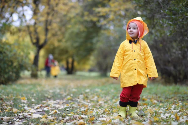 Ett barn i en regnrock för en promenad utanför — Stockfoto