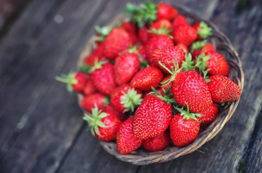 Hasır plaka ahşap arka plan üzerinde çilek