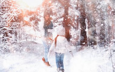 Genç bir aile yürüyüşe çıktı. Anne ve kızı şarapla yürüyorlar.