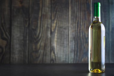 Masada şeffaf beyaz şarap şişesi var. Beyaz şarap!