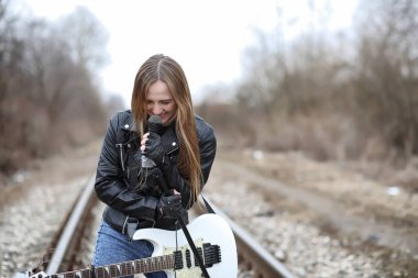  Bir gitar ile deri ceketli bir rock müzisyen kız 