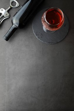 Şarap kadehi ve siyah şarap şişesi. Ceviz peyniri ve domates.