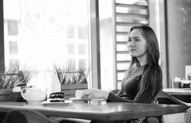 Kız bir kafede oturan ve çay içme