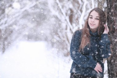 Kış parkında kar yağan bir kız