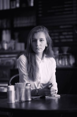 Bir kız bir kafede kahve içiyor. Bir kadın kahvaltı yapıyor