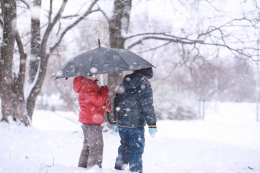 Çocuklar parkta ilk kar yürümek