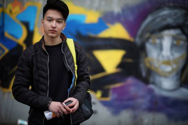 Asya genç adam kameraya poz sokakta