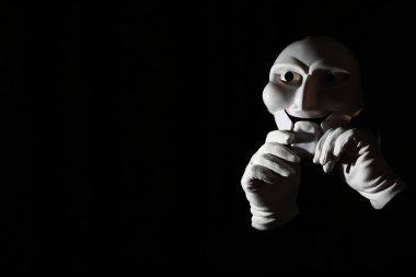 Siyah arka planda beyaz, korkunç bir maske..